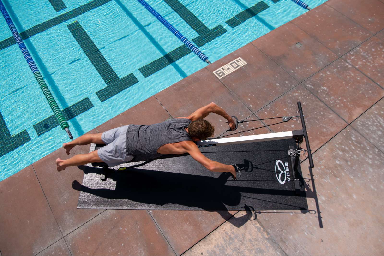 Ovehead view of Trainer Pro in use beside pool practicing double arm pulls (DAP)